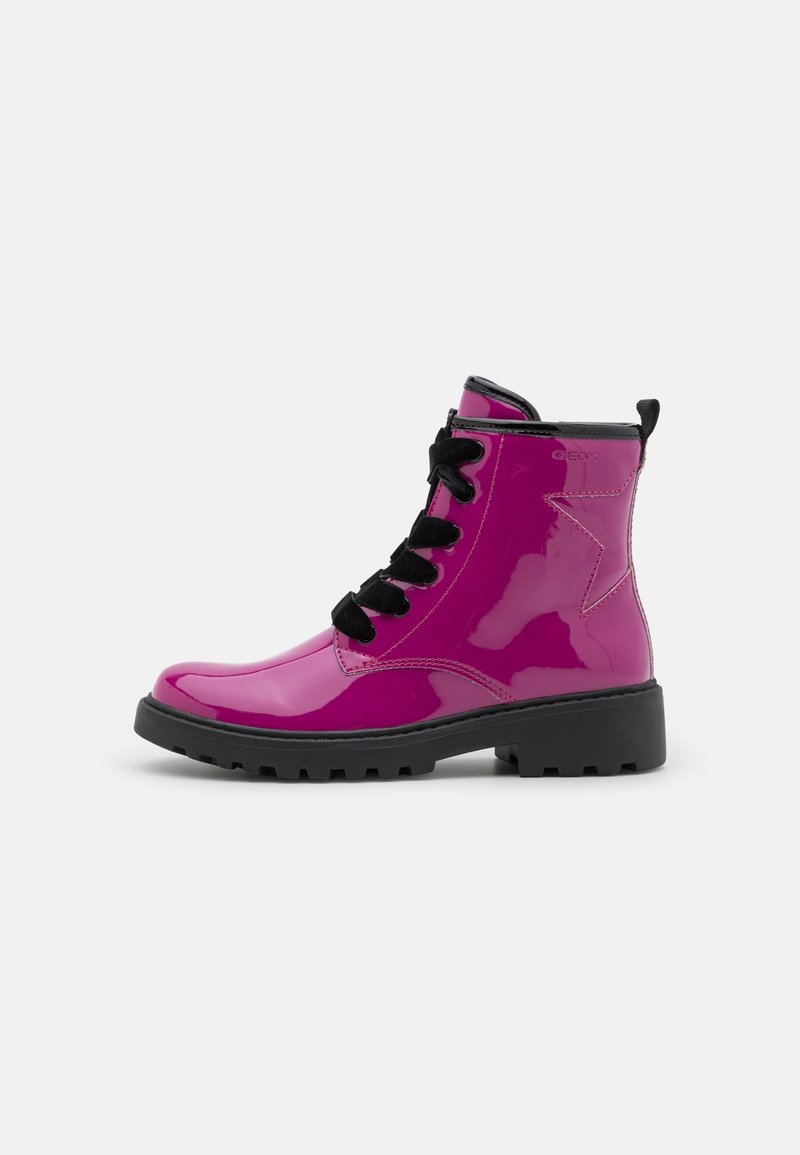 Bottine brillante rose foncé avec semelle épaisse noire et lacets noirs, avec un motif étoile cousu sur le côté.
