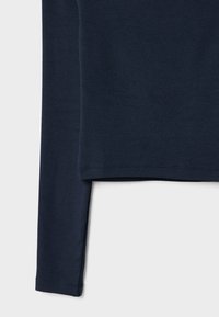 Top à manches longues marine en tissu doux et extensible. Il présente un col rond et un ourlet droit, avec des coutures simples le long des bords.