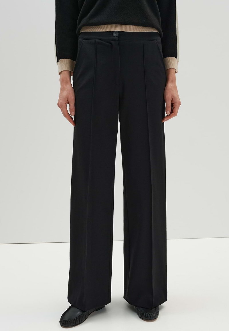 Black wide-leg trousers made of smooth fabric, featuring a front button closure, two side pleats, and a tailored fit.