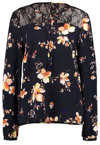 Blouse à fleurs bleu marine avec des fleurs orange et jaunes. Dotée d'un empiècement en dentelle, de manches longues, d'un détail à nouer au cou et d'une coupe décontractée.