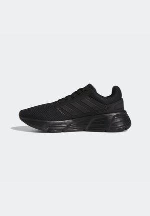 Black athletic shoes with a textured mesh upper, lace closure, and three bold stripes on the side. Cushioned sole for comfort.