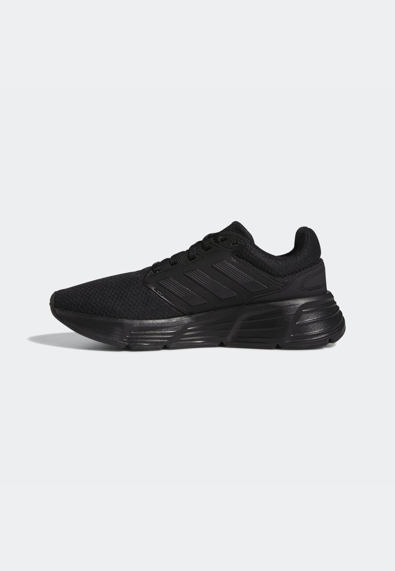 Zapatillas deportivas negras con una parte superior de malla texturizada, cierre de cordones y tres franjas en negrita en el lateral. Suela acolchada para mayor comodidad.
