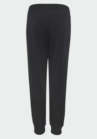 Pantalons de sport noirs avec un design fuselé, taille élastique et poignets côtelés. Présente des bandes blanches sur les côtés et une texture lisse.