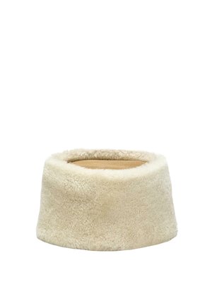 Rundes beige Lammfell-Haustierbett mit weichen Plüschseiten und einem flachen Wildlederkissen in der Mitte auf weißem Hintergrund.