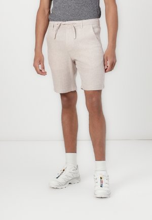 Beige shorts i en tekstureret stof, med en snøre i taljen, sidelommer og en kant over knæet.