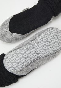 Calcetines de lana gris oscuro y gruesos, con parte superior de fieltro gris y suelas de goma texturizadas que presentan un patrón de diamantes para mayor agarre y durabilidad.