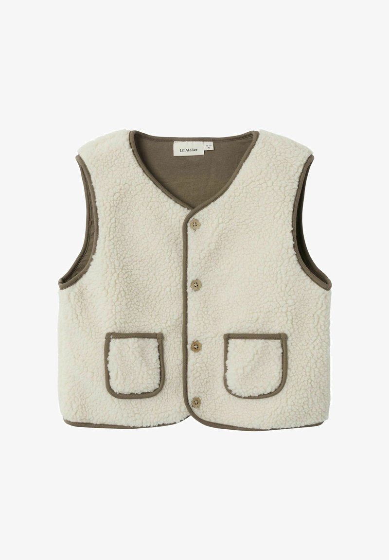 Krēms krāsas vilnas veste ar V veida kakla izgriezumu, pogu aizdari un kontrastējošu brūnu apdari. Satur divas priekšējās kabatas ar noapaļotām malām.