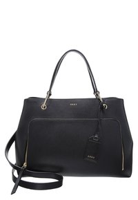 Musta nahkainen käsilaukku, jossa on jämäkkä muotoilu, kaksi yläkahvaa, vetoketjutaskut, kullanväriset yksityiskohdat ja irrotettava merkintä, jossa näkyy brändin nimi.