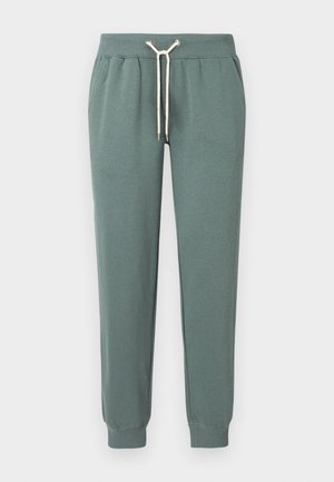 Pantalones joggers de algodón verdes con cintura ajustable con cordón y puños acanalados. Textura suave con bolsillos laterales y detalles en el cordón de color contrastante.