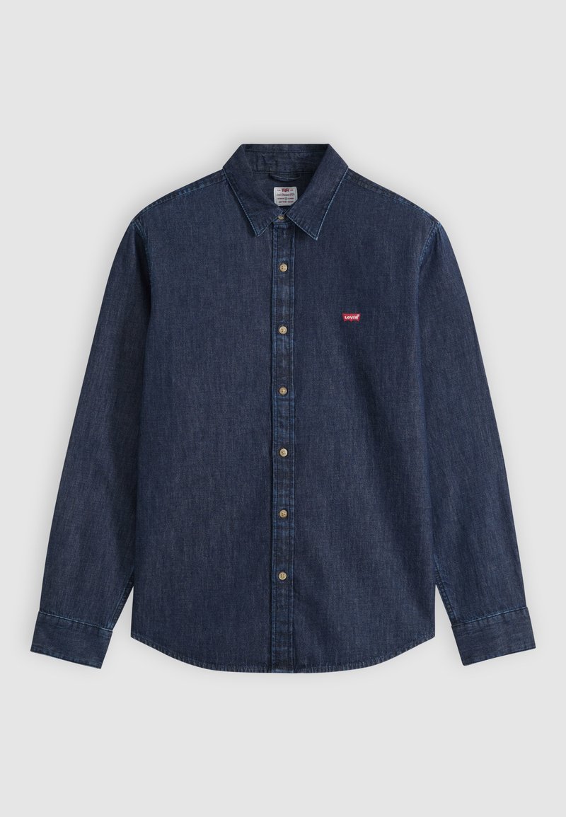 Chemise en denim bleu foncé à manches longues, boutonnée, avec col pointu et petit logo rouge Levi's sur la poitrine gauche.