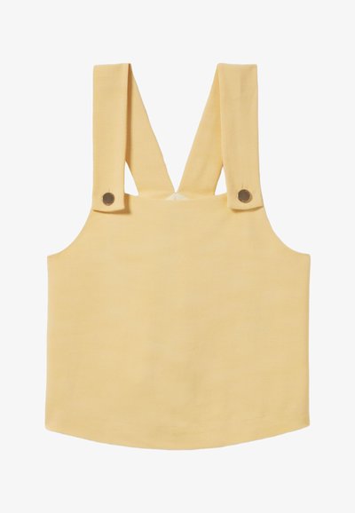 Débardeur jaune sans manches avec larges bretelles, présentant des boutons métalliques ronds aux épaules et un tissu lisse et texturé.