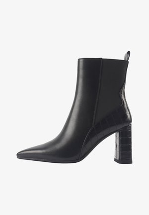 Schwarze Knöchelboots mit spitzem Zehenbereich, strukturiertem Leder und einem Krokodilmuster-Akzent an der Ferse. Erhöhter Blockabsatz für zusätzliche Unterstützung.