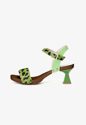 Sandalias de estampado de leopardo verde con suela de madera y un tacón angular verde brillante. Presenta una correa en el tobillo con una hebilla plateada y acentos dorados.