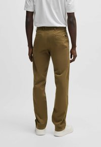 Khaki bukser med lige pasform, blød bomuldsblanding, for- og baglommer samt et minimalistisk design. Bæres med en hvid t-shirt.