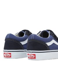 Marine og lyseblå semsket sneakers med hvite detaljer, lav design, polstret krage og rød logotag på hælen.