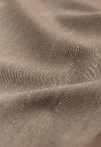 Tessuto marrone strutturato con una leggera lucentezza. Presenta un motivo a righe diagonali sottili e una superficie morbida e leggermente increspata.