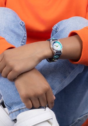 Orologio colorato con cassa argentata, quadrante bianco e accenti turchesi su un cinturino blu con motivi giocosi.