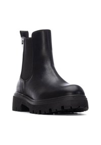 Bota de cuero negra hasta el tobillo con paneles laterales elásticos, punta redondeada, suela de goma gruesa y textura en la suela para mayor agarre.