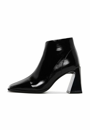 Zwarte gepatineerde leren enkellaarsjes met een spitse neus en een glanzende blokhak. Gladde textuur zonder zichtbare patronen of hardwaredetails.