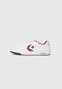 White low-top sneakers with maroon accents, including a star logo and side stripe. Features a textured upper and rubber sole.