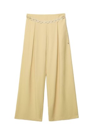Bež široke hlače z gubami in srebrnim pasom z verigo s krožnimi povezavami, ki je pritrjena čez pas.