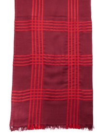 Textile bordeaux avec des rayures rouges horizontales et verticales, doté d'un bord frangé. Le tissu a une texture lisse avec un motif régulier.