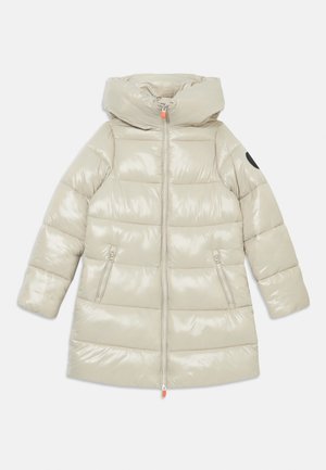 Beige pufferjakke med en blank finish, hette, to lommer med glidelås på siden, og en kontrasterende svart lapp på den ene ermen.