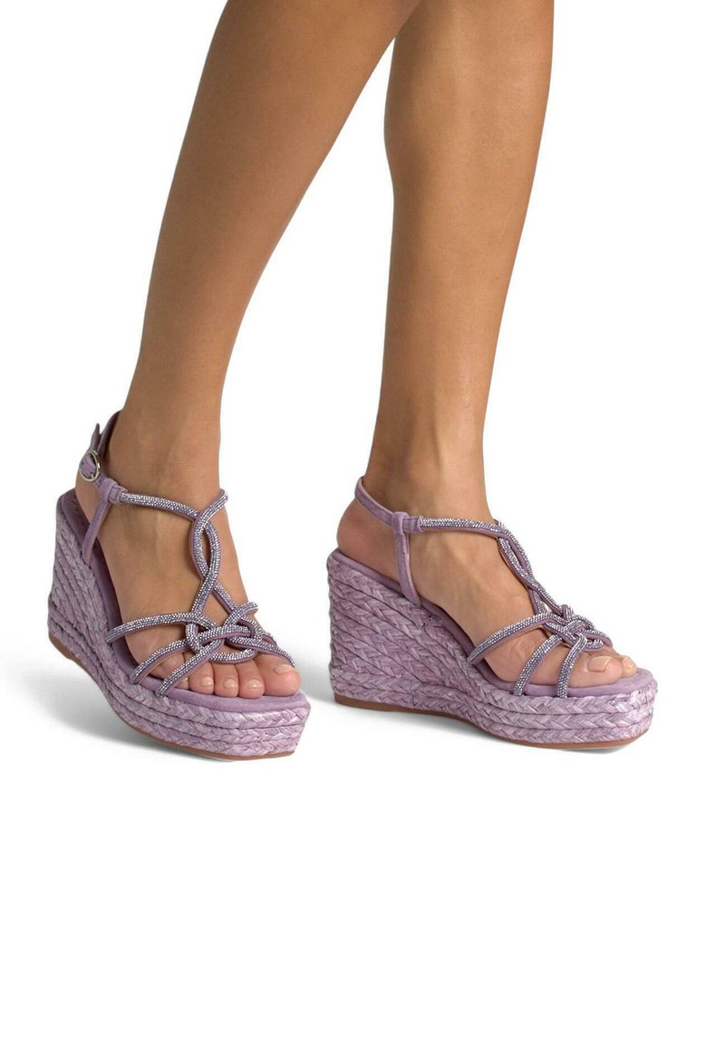 Sandali con tacco a cuneo lilla caratterizzati da una base in rafia intrecciata, un design del cinturino texturizzato con accenti metallici e uno stile open-toe.