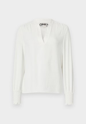 Weißes Langarmshirt mit V-Ausschnitt und gerafften Manschetten. Hergestellt aus weichem Stoff, mit lockerer Passform und subtiler Textur. Markenschild sichtbar.