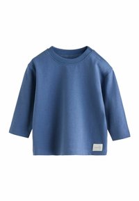 Blauw baby shirt met lange mouwen, voorzien van drukknoopjes op de linkerschouder en een klein wit etiketje aan de onderrand rechts.