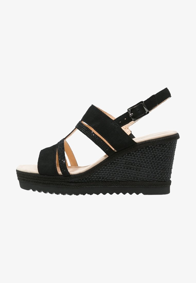 Sandale noire à plateforme compensée avec talon texturé, trois brides croisées ornées de petites décorations, et une bride de cheville ajustable avec boucle.