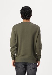 Felpa verde oliva con colletto rotondo, maniche lunghe e polsini a coste. Realizzata in un materiale morbido, presenta una texture semplice e liscia.