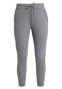 Grå sweatpants med dragsko i midjan, slim fit och fickor på sidan med dragkedja, tillverkade av mjukt, texturerat material.