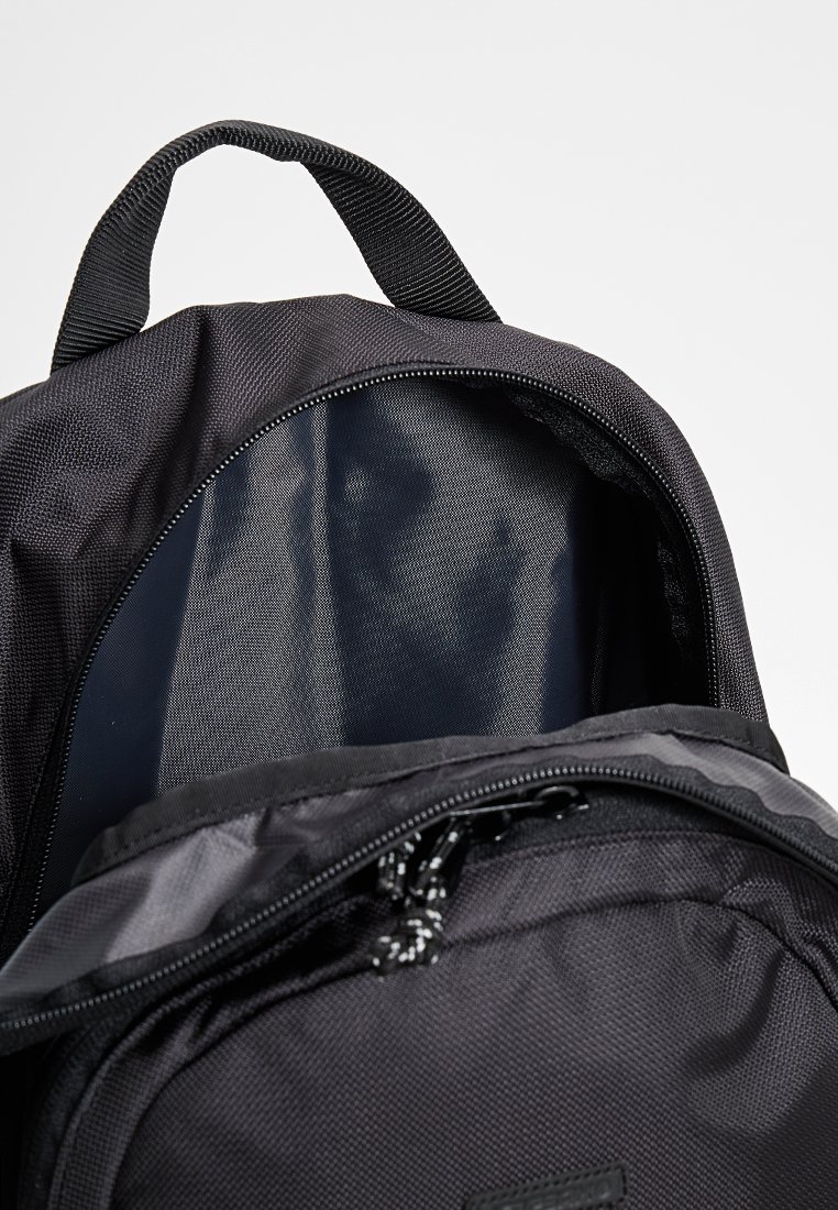 Zwarte rugzak met een stevige buitenkant, textuur van stof, een ritsopening aan de bovenkant en zichtbare binnenvoering, in een diep marineblauwe kleur.