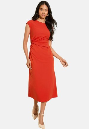 Red midi dress with cap sleeves, gathered detailing at the waist, and a smooth texture. Paired with light-colored high-heeled shoes.