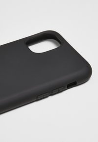 Coque de smartphone noire avec une finition mate, découpe pour la caméra et ouvertures pour les boutons de volume et le port de chargement.
