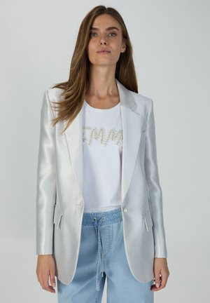 Silver metallic blazer with a tailored design, notched lapels, and two front pockets. Paired with a white shirt featuring pearl detailing.