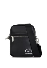 Čierna kožená crossbody taška so striebornými kovovými prvkami, so zipsom, textúrovaným povrchom a výrazným bielym brandingom na prednej strane.