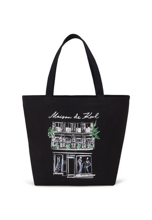 Black canvas tote bag featuring an illustrated storefront design with green accents, windows, and figures in blue dresses.