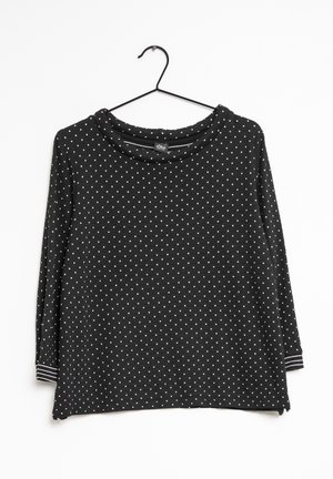 Haut noir à manches longues avec des pois blancs, doté d'un large col et d'accents rayés au niveau des poignets. Fabriqué en tissu texturé.