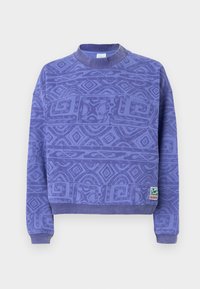 Lila sweatshirt med en texturerad geometrisk mönster, ribbad rundhals och muddar. Inkluderar en liten varumärkesetikett vid fållen.