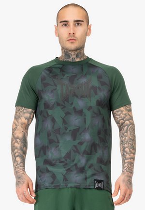Grøn camo T-shirt med et mønsterdesign, som har et sort logo og korte ærmer. Lavet af letvægtsstof for åndbarhed.