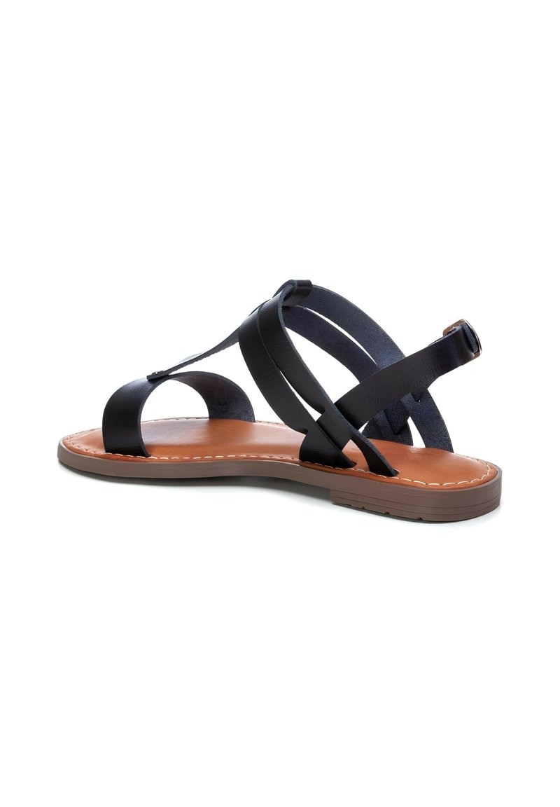 Sandalo in pelle nera con suola piatta in gomma, caratterizzato da cinghie incrociate e una soletta imbottita. Le cuciture marroni a contrasto accentuano il design.