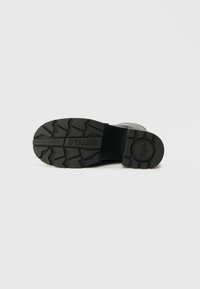 Μαύρη σόλα από καουτσούκ με βαθιά τρέντι για πρόσφυση, τολμηρή σήμανση 'BUFFALO' εγχάρακτη στο πλάι, ανθεκτικός, επίπεδος σχεδιασμός.