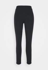 Zwarte leggings met een slimfit ontwerp, elastische tailleband en een gladde textuur. Zijschoenen geaccentueerd met een subtiele contrasterende bies.