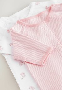 Dos bodies para bebés: uno blanco con estampados de conejitos y el otro rosa con rayas blancas. Ambos tienen mangas cortas y cierres a presión. Material de algodón suave.