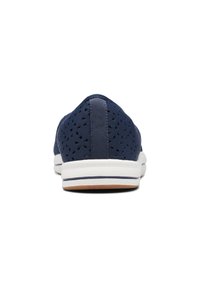 Marineblauwe doorlatende sneaker met een platte witte zool, achterste lus en lichtbruine rubberen loopzool. Eenvoudig ontwerp met ademend materiaal.
