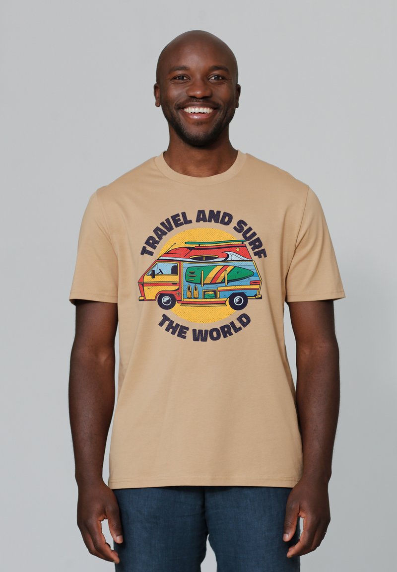 Beige katoenen t-shirt met een kleurrafische afbeelding van een bus met surfplanken, met de tekst "REIS EN SURF DE WERELD" in vette letters.