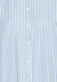 Light blue and white vertical striped fabric with white buttons sewn down the center.
