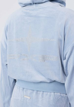 Lichtblauwe velours hoodie met een gestructureerd oppervlak, voorzien van strasstenenaccenten die een sterontwerp op de achterkant vormen en een geribde tailleband.